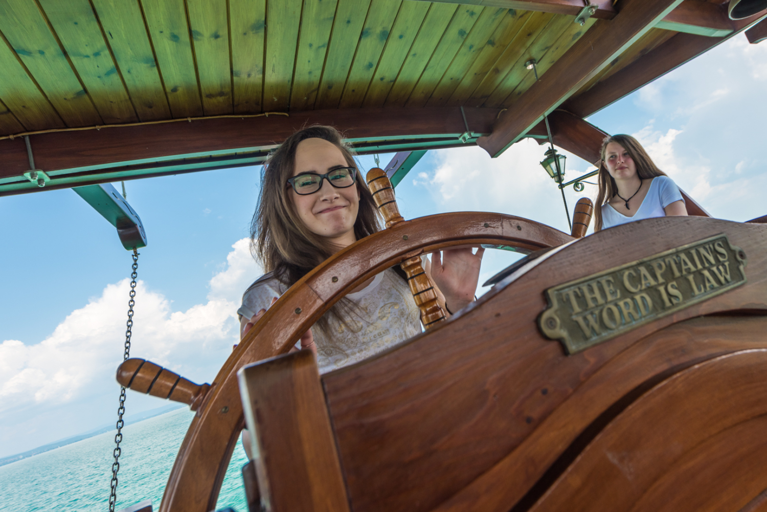 Élmény a vízen. Lány kalózhajót kormányoz.